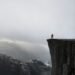 Personne debout au bord d’une falaise dans la brume